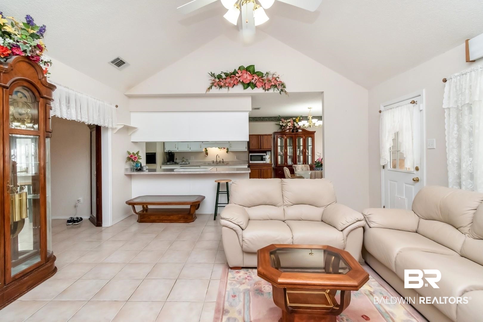 8221 Woodbend Drive Semmes, AL 36575 - Photo 11 of 35 Tiled living room featuring vaulted ceiling and ceiling fan with notable chandelier