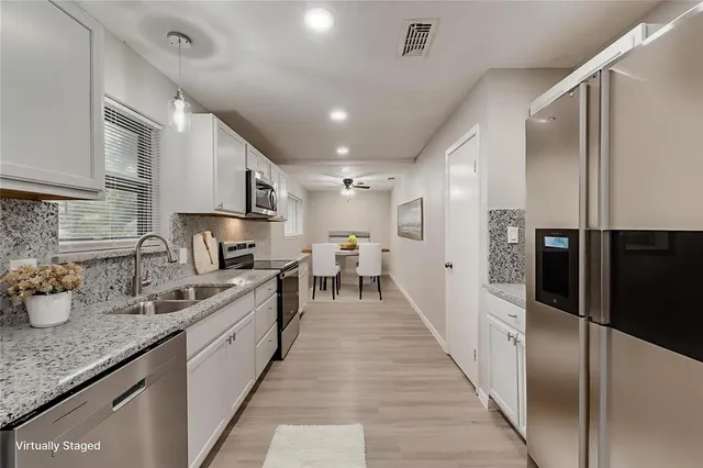 a large kitchen with stainless steel appliances lots of counter top space