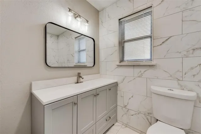 a bathroom with a toilet sink and mirror