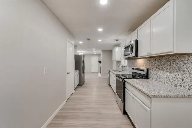 a kitchen with stainless steel appliances granite countertop a stove a sink and a refrigerator