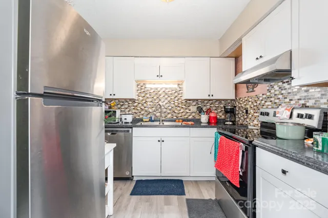 a kitchen with granite countertop a refrigerator and a sink