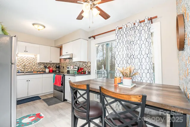 a open dining room with stainless steel appliances kitchen island granite countertop a table and chairs