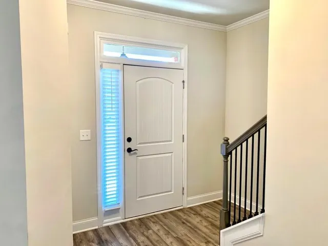 a view of a hallway with wooden floor and staircase