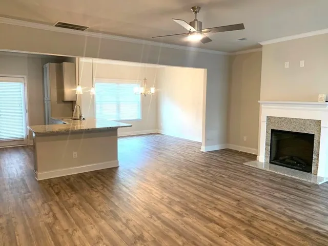 a view of a kitchen and an empty room with a fireplace