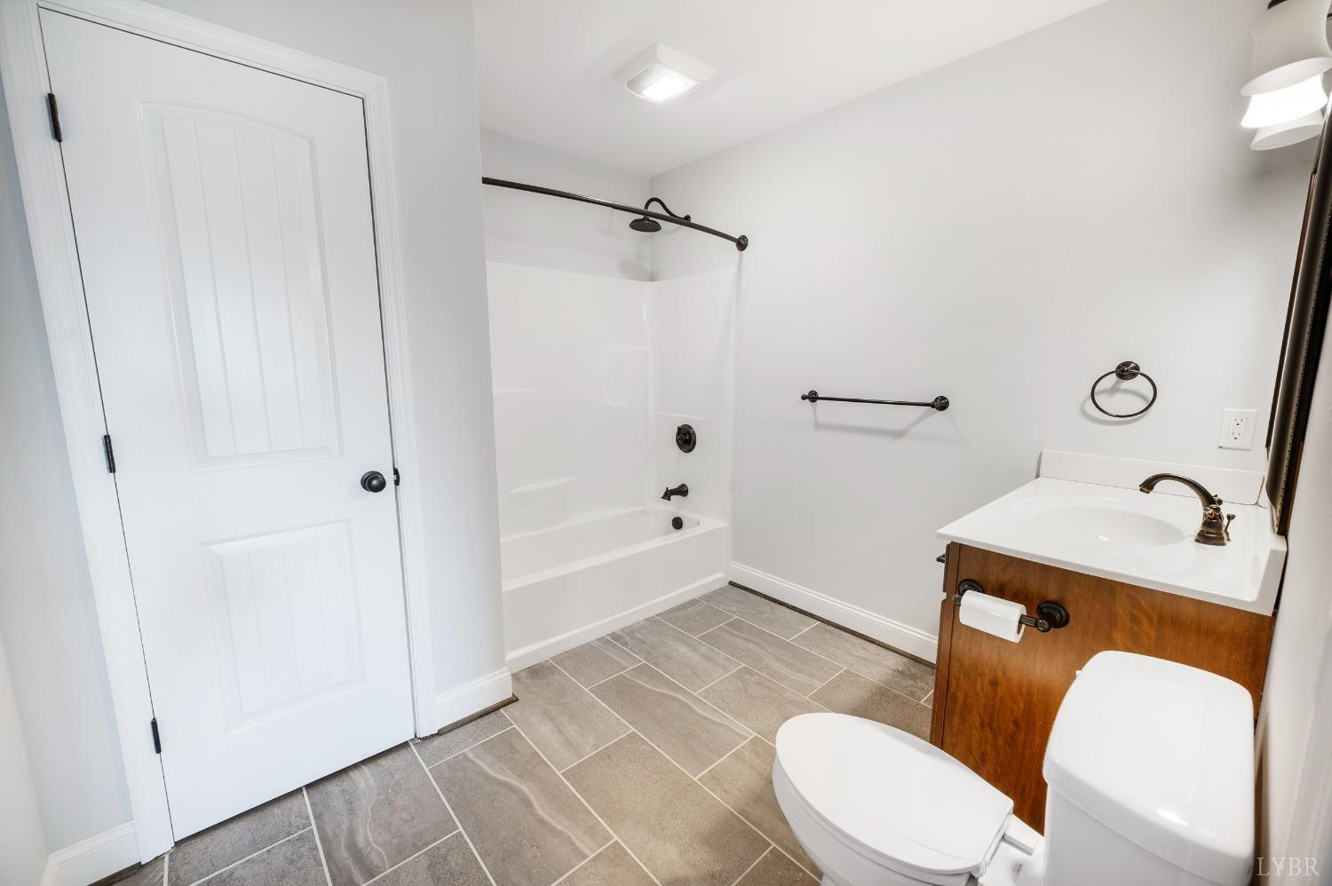 1695 Colby Drive Forest, VA 24551 - Photo 55 of 92 a white toilet sitting next to a bathroom sink and a shower