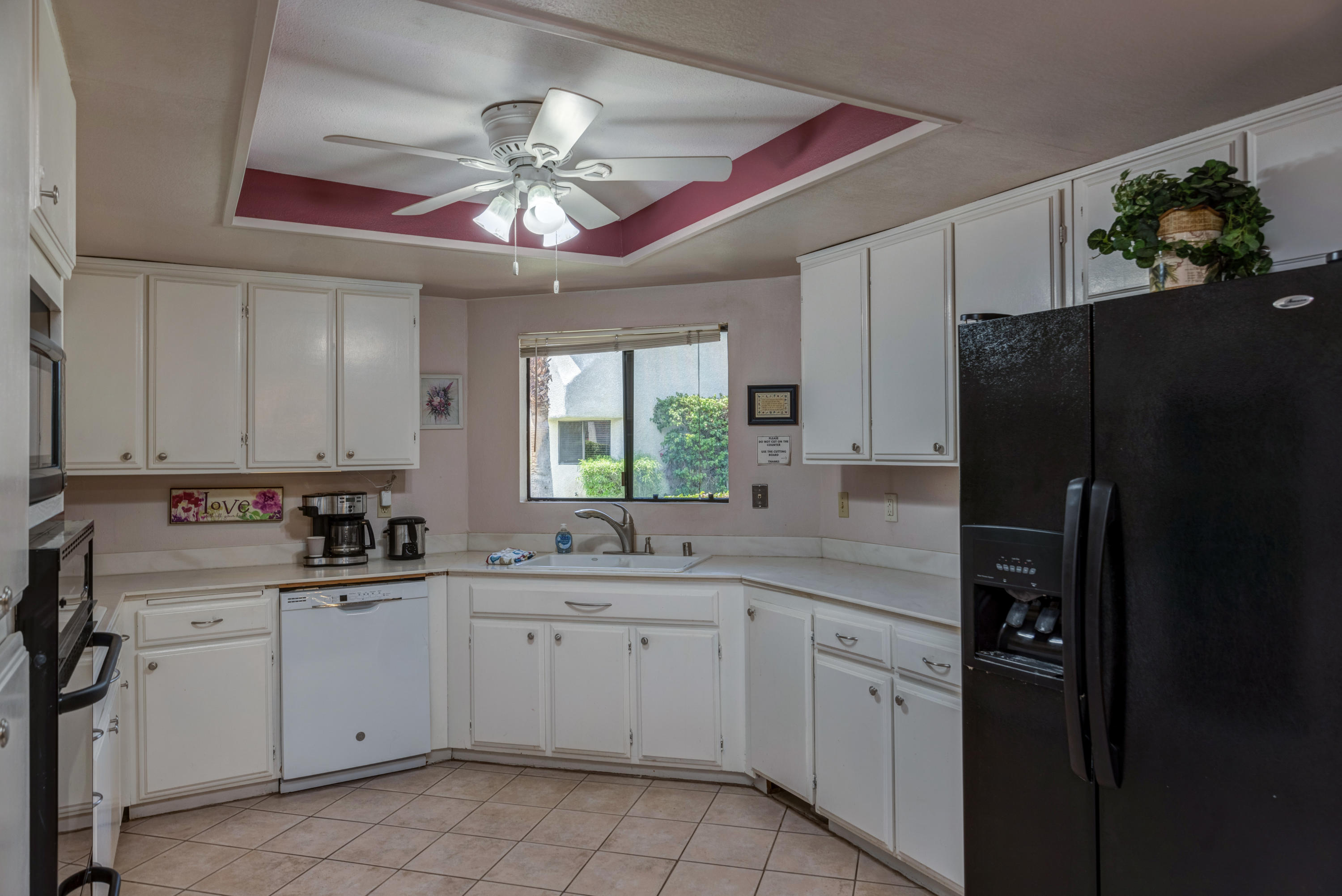 3155 Ramon Road, Unit 503 Palm Springs, CA 92264 - Photo 6 of 21 a kitchen with a sink dishwasher a refrigerator a stove and white cabinets