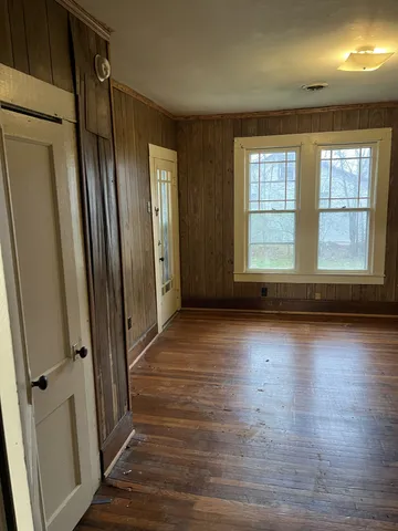 an empty room with wooden floor and a window