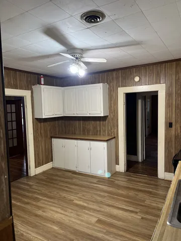 a view of a hallway with wooden floor and staircase