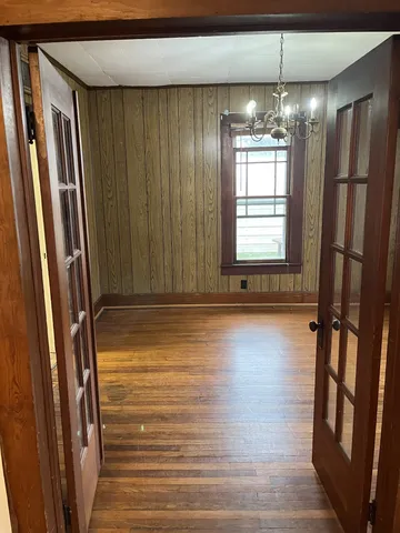 a view of empty room with wooden floor and fan