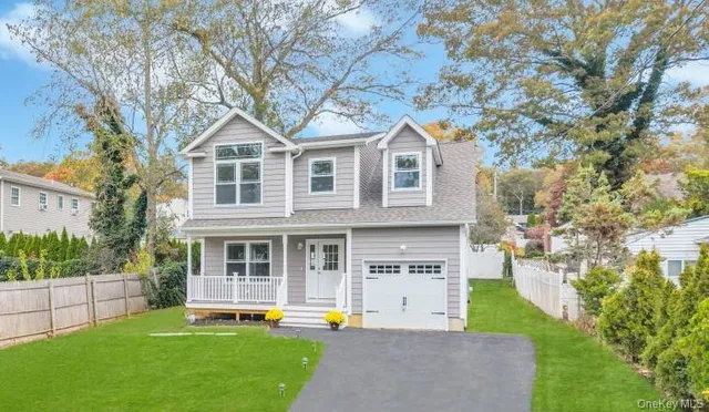a front view of a house with a yard and trees