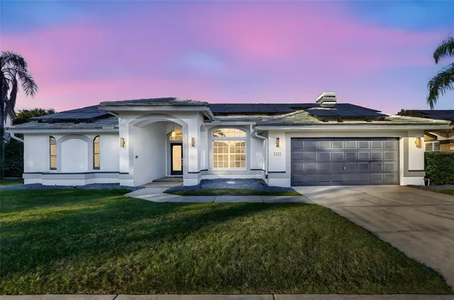 a front view of a house with a garden and yard