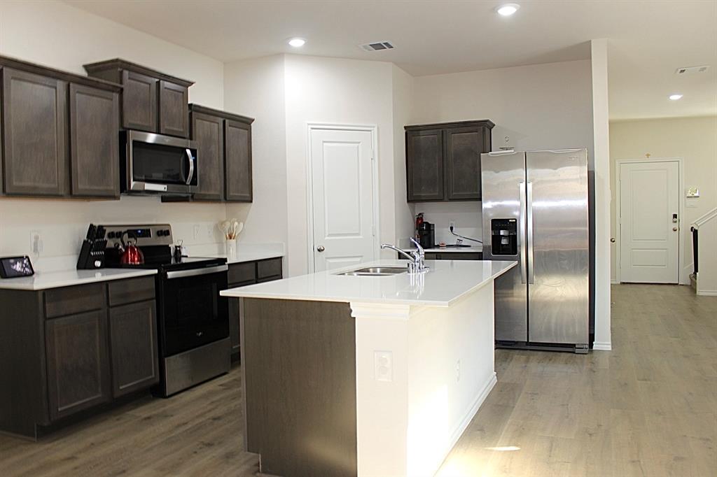 821 Country Road Royse City, TX 75189 - Photo 6 of 15 a kitchen with kitchen island stainless steel appliances cabinets a sink and a refrigerator