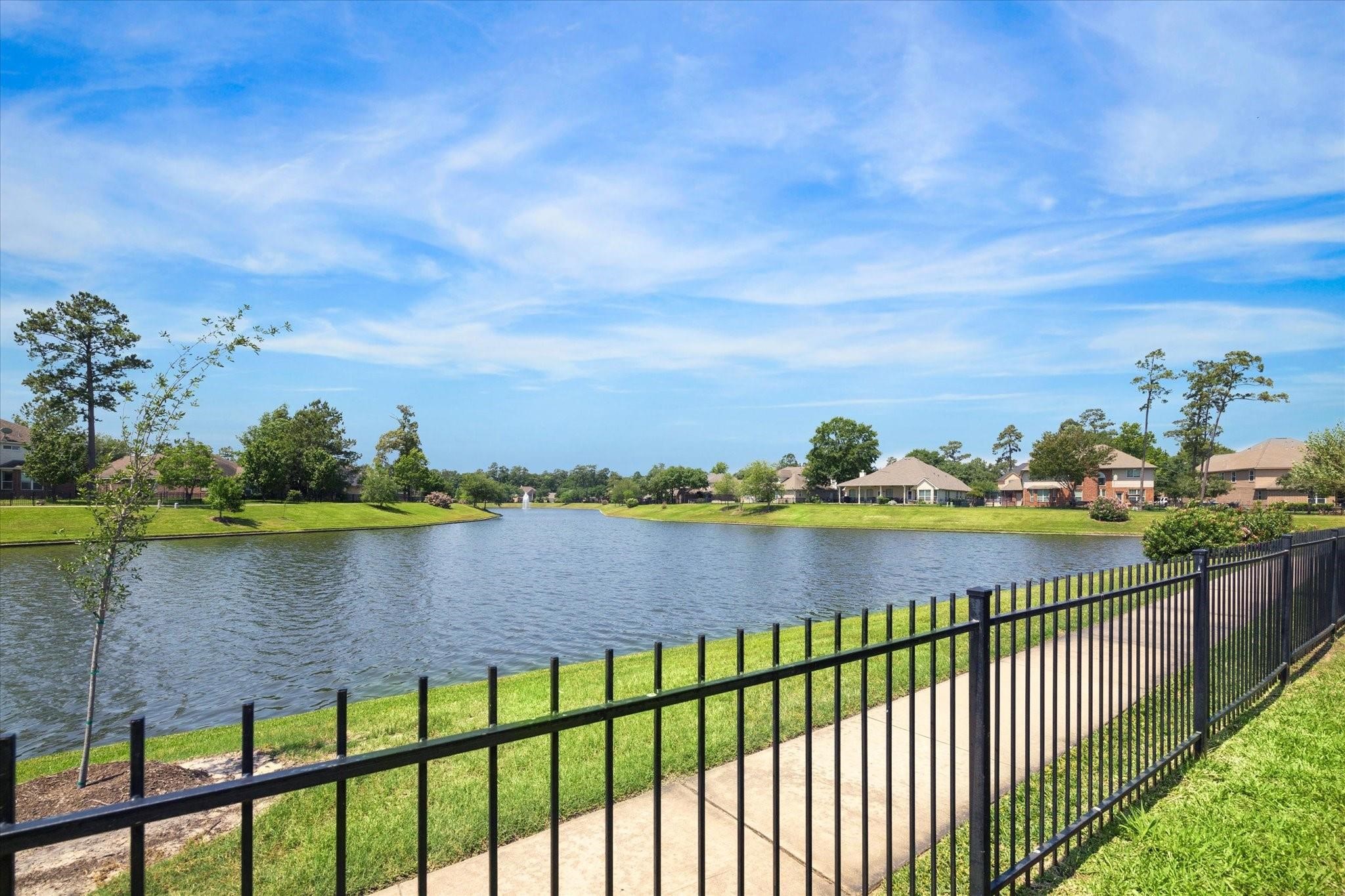 30507 Russell Point Drive Spring, TX 77386 - Photo 2 of 33 This gorgeous scenic view of the serene lake bordered by a well-maintained lawn and a paved pathway could be yours.