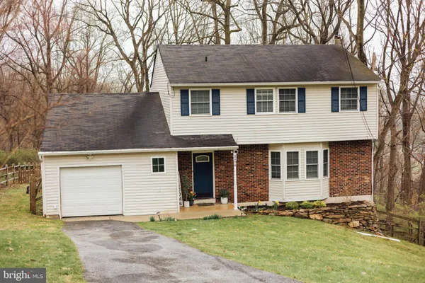a front view of a house with a garden and yard