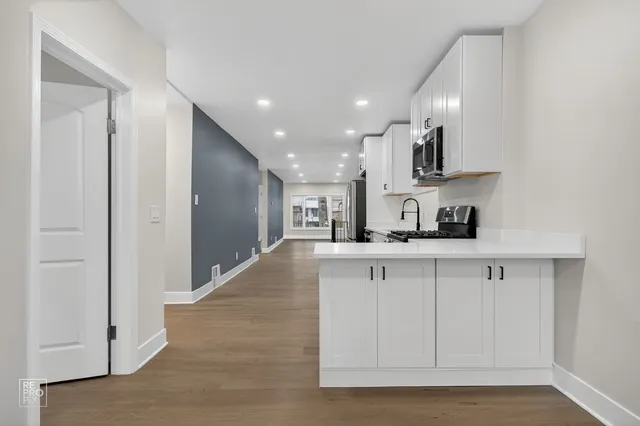a kitchen with stainless steel appliances granite countertop a refrigerator and a sink