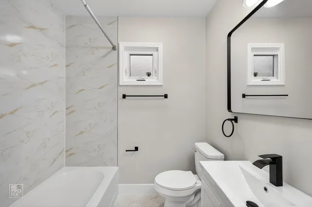 a bathroom with a toilet a sink and bathtub