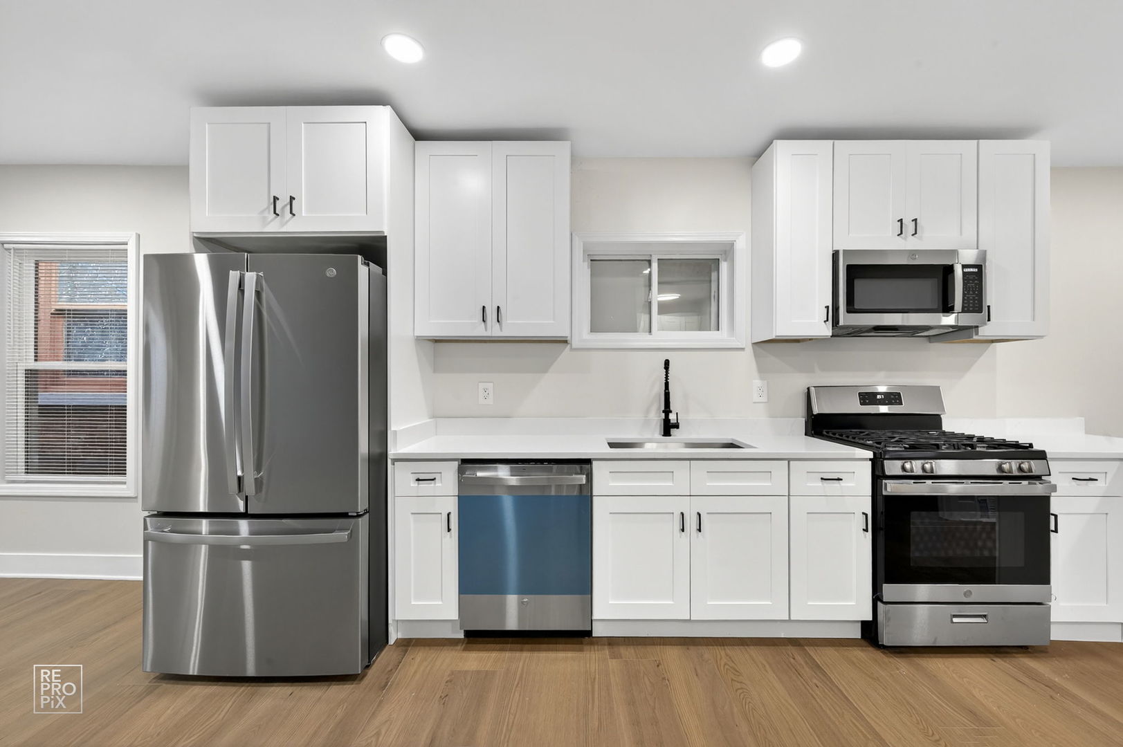 8420 South Carpenter Street Chicago, IL 60620 - Photo 3 of 23 a kitchen with cabinets stainless steel appliances and wooden floor