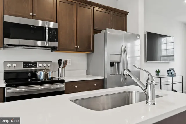 a kitchen with stainless steel appliances wooden cabinets a sink and a microwave