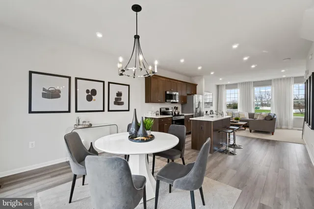 a view of a dining room and livingroom with furniture wooden floor a chandelier