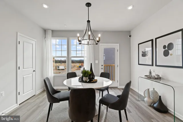 a dining room with furniture a chandelier and wooden floor