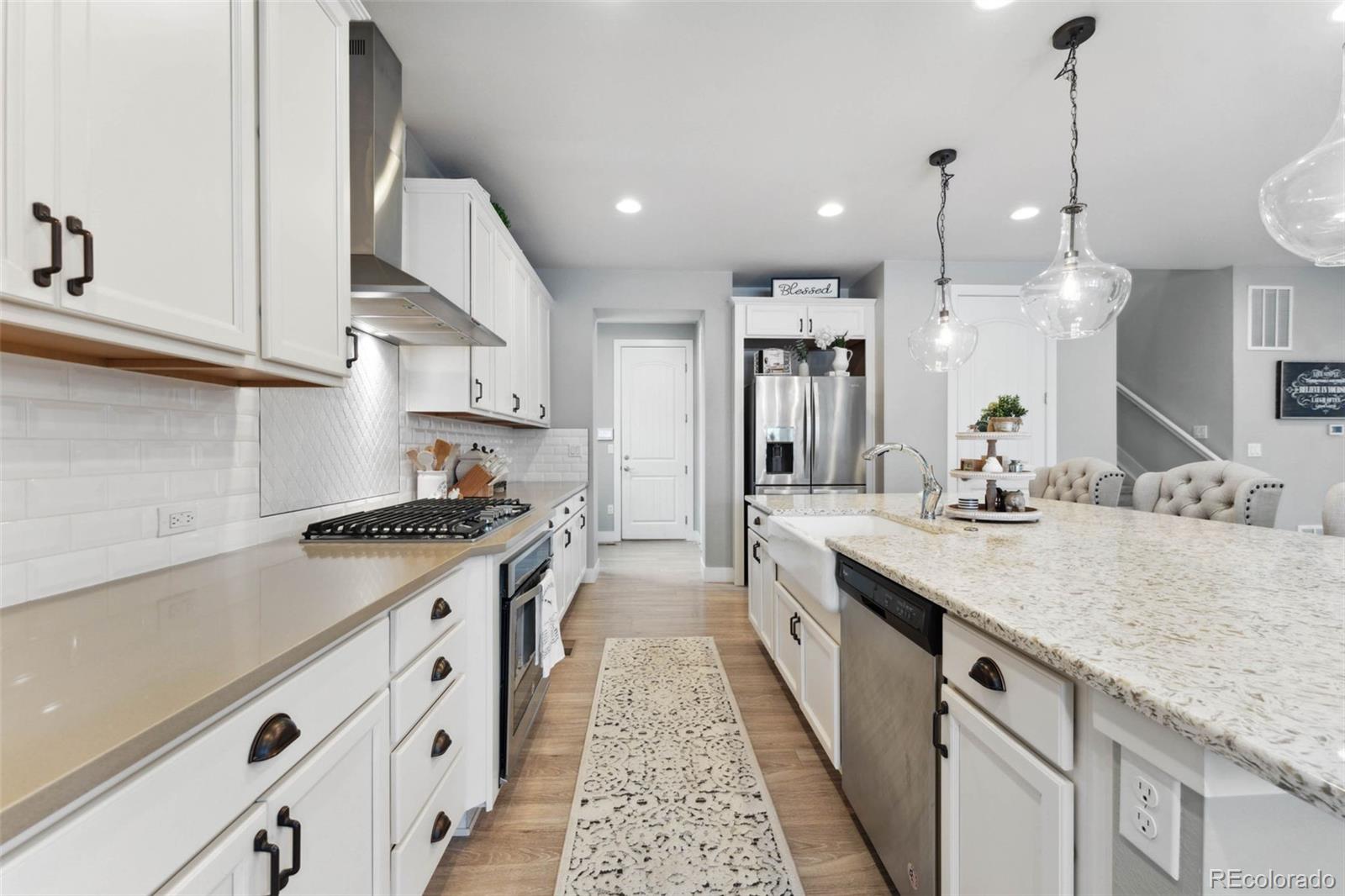9459 Gore Loop Arvada, CO 80007 - Photo 14 of 50 a kitchen with granite countertop a sink stove and cabinets