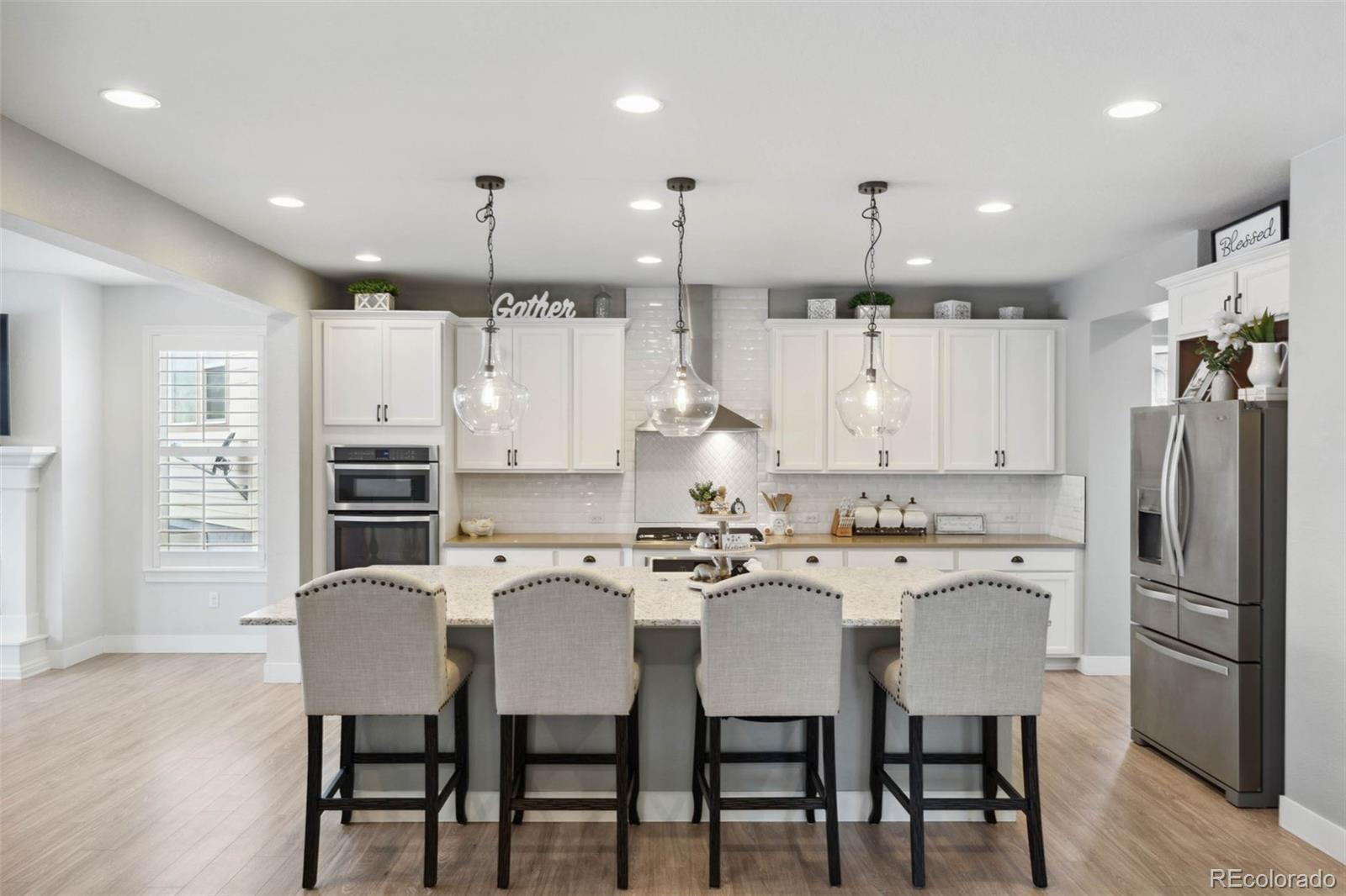 9459 Gore Loop Arvada, CO 80007 - Photo 15 of 50 a kitchen with stainless steel appliances granite countertop a kitchen island a stove a table and chairs