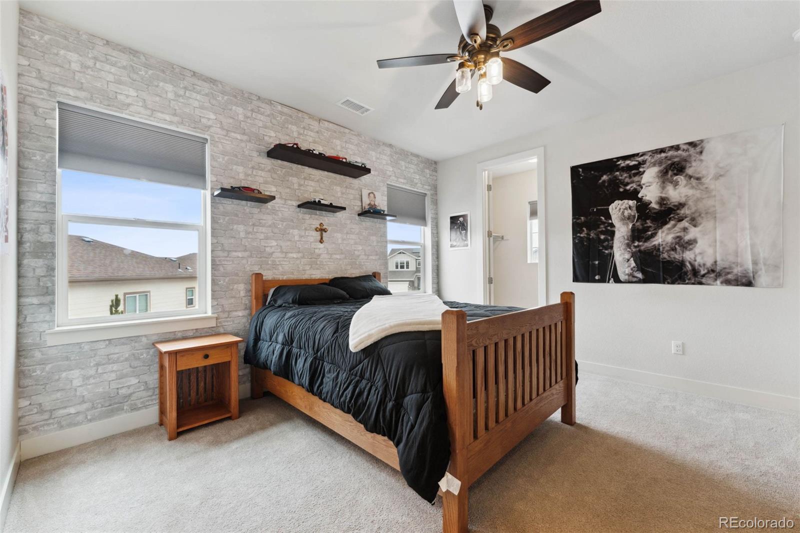 9459 Gore Loop Arvada, CO 80007 - Photo 33 of 50 a spacious bedroom with a bed and a chandelier