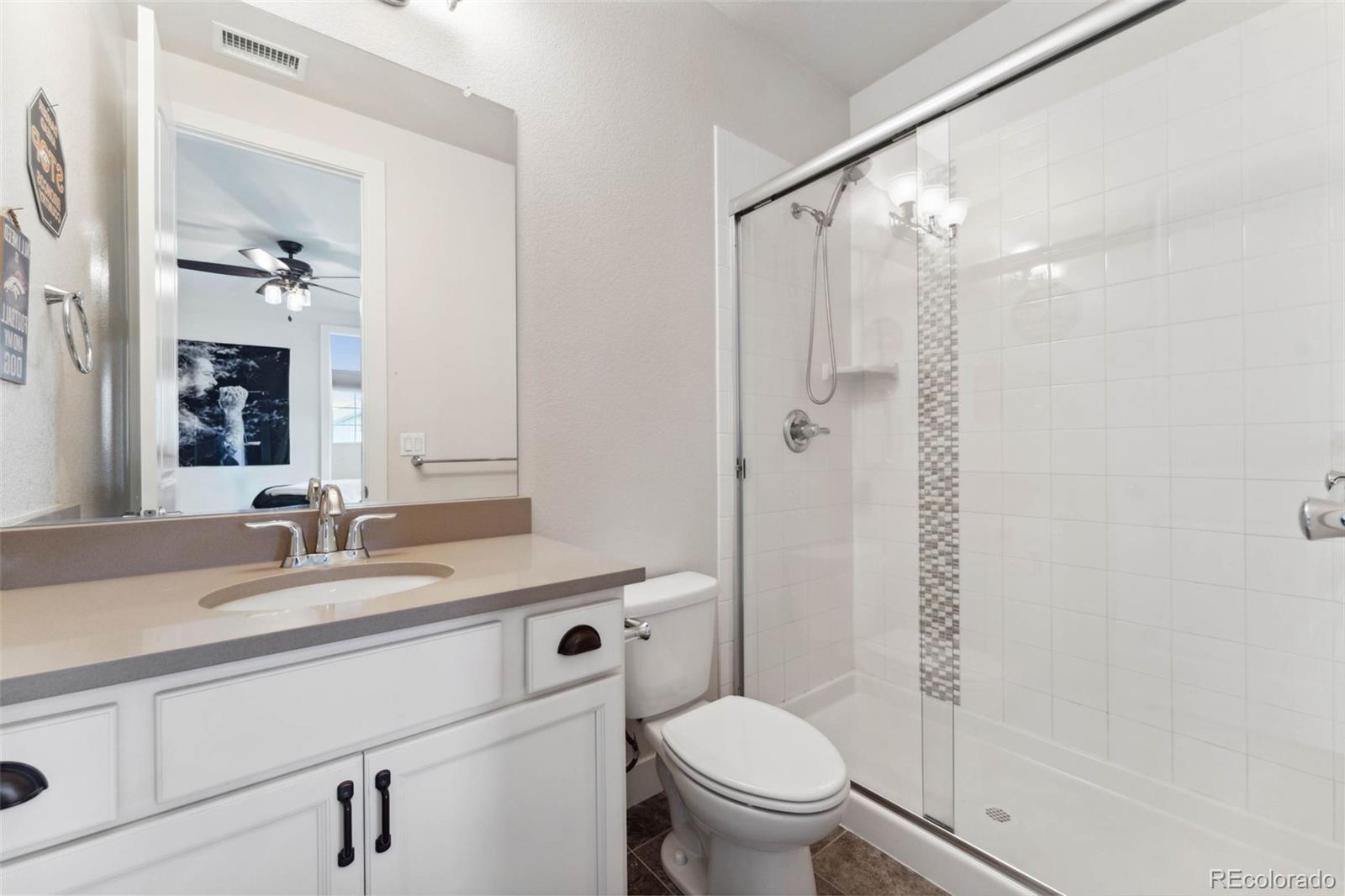9459 Gore Loop Arvada, CO 80007 - Photo 34 of 50 a bathroom with a granite countertop sink toilet and shower