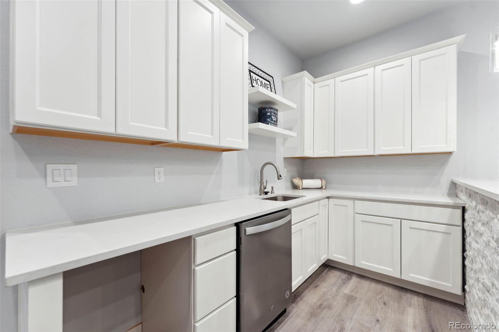 9459 Gore Loop Arvada, CO 80007 - Photo 39 of 50 a kitchen with stainless steel appliances granite countertop a sink and dishwasher with white cabinets
