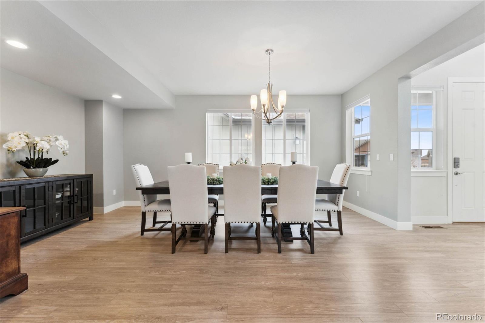 9459 Gore Loop Arvada, CO 80007 - Photo 7 of 50 a view of a dining room with furniture and wooden floor