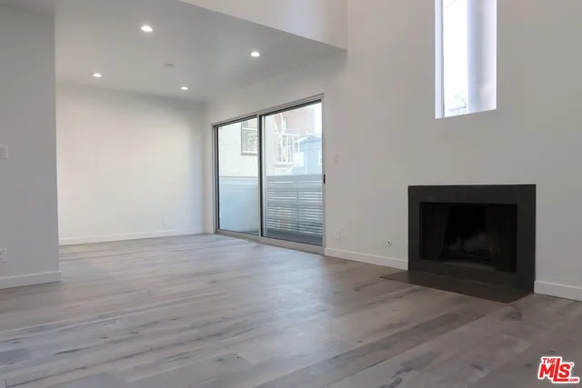 an empty room with wooden floor and fireplace
