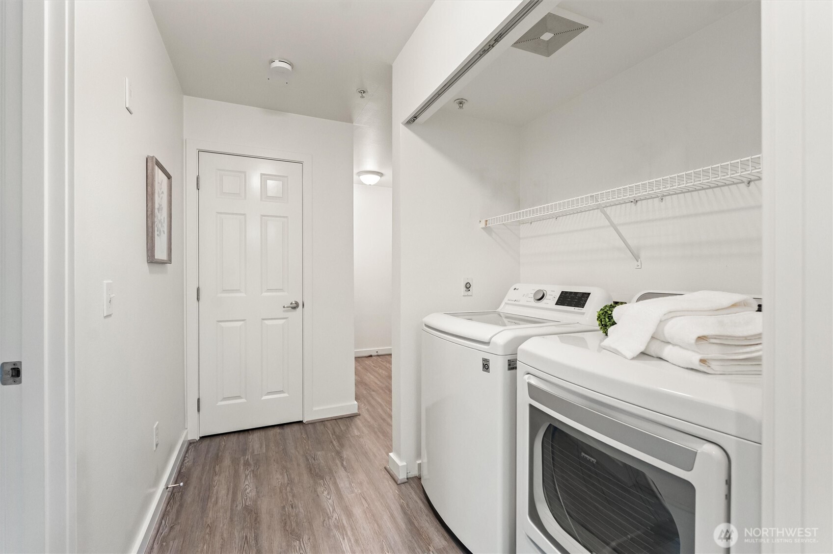 15150 140th Way Southeast, Unit S103 Renton, WA 98058 - Photo 16 of 40 a view of washer and dryer with kitchen in the background