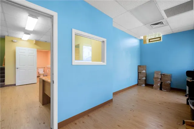 a view of empty room with wooden floor and bathroom