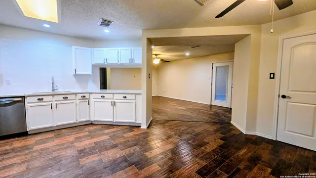 a kitchen with a sink cabinets and wooden floor
