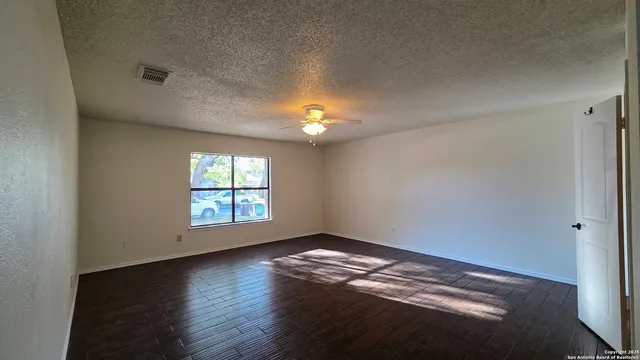 wooden floor in an empty room with a window