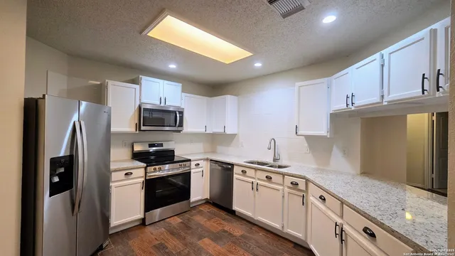 a kitchen with a sink stainless steel appliances and cabinets