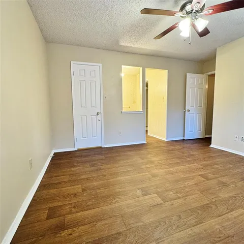 a view of an empty room and chandelier fan