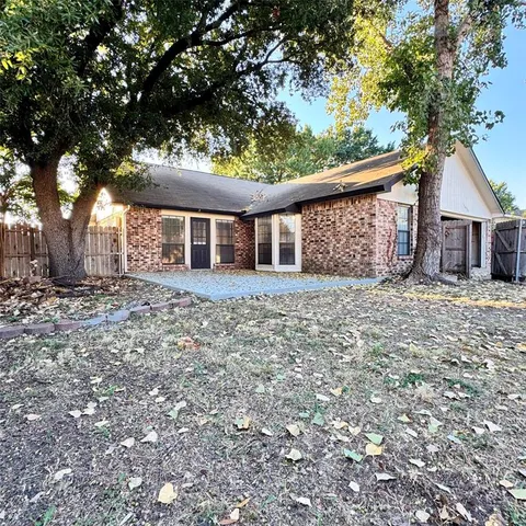front view of a house with a large tree and a yard