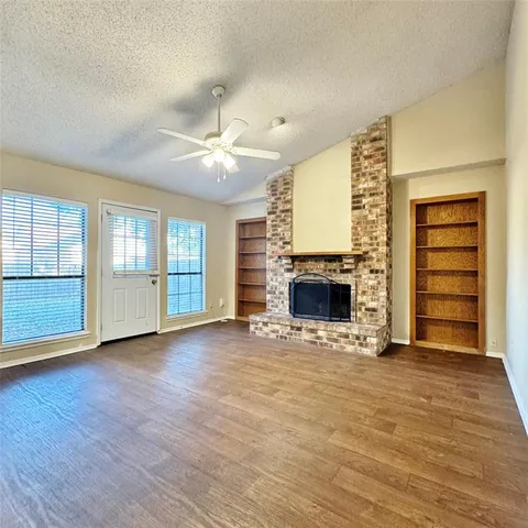 a view of an empty room with a fireplace and a window