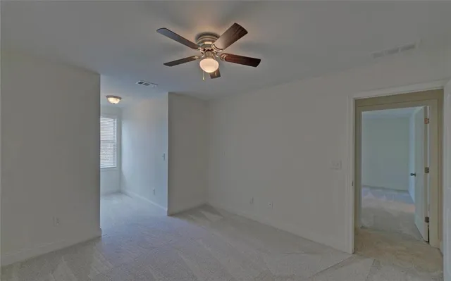an empty room with closet and fan