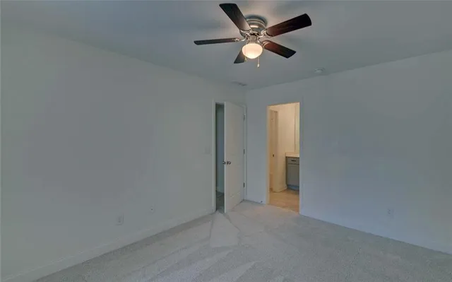 an empty room with a ceiling fan and a window