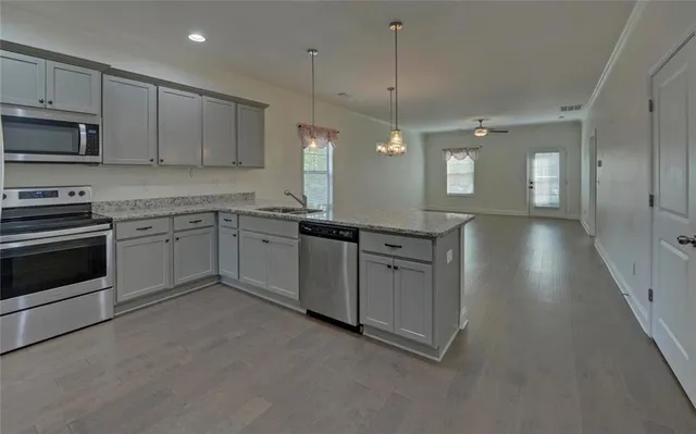 a kitchen with stainless steel appliances granite countertop a stove a sink and a refrigerator