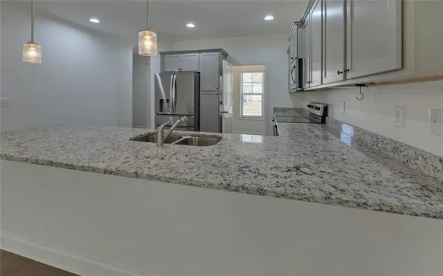 a kitchen with sink refrigerator and microwave