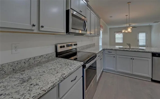 a kitchen with granite countertop cabinets stainless steel appliances and a sink