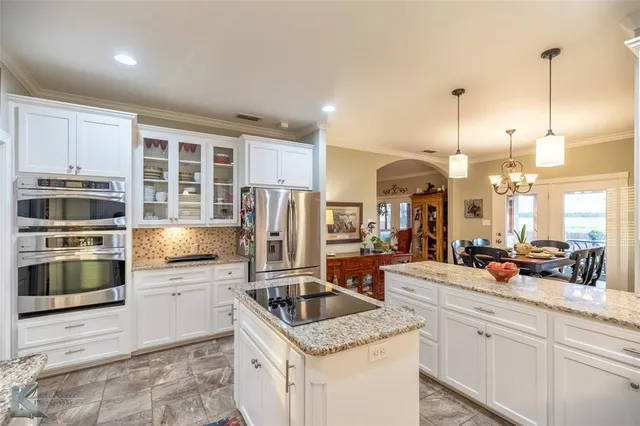 a kitchen with stainless steel appliances granite countertop a sink a stove and a refrigerator