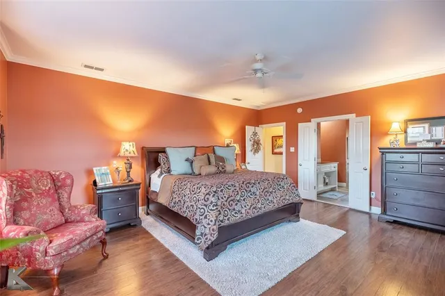a spacious bedroom with a bed and wooden floor