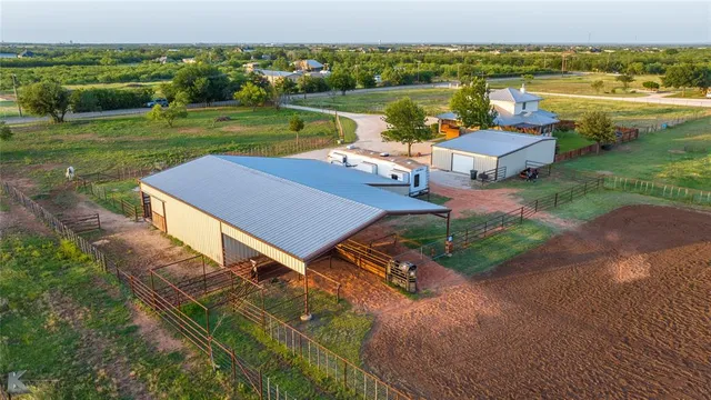 an aerial view of a house with a yard and lake view