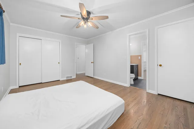 a bedroom with a large bed and a chandelier
