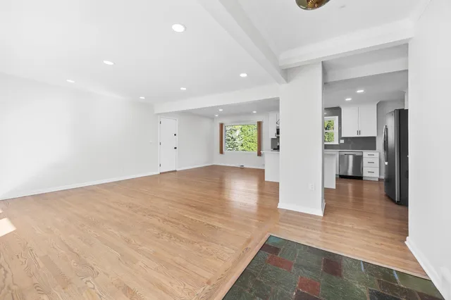 a view of a kitchen with kitchen island a sink wooden floor and a large window