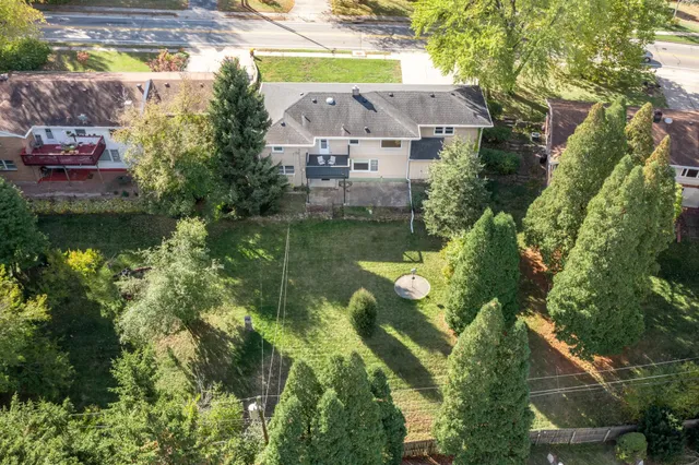 an aerial view of residential houses with outdoor space and trees